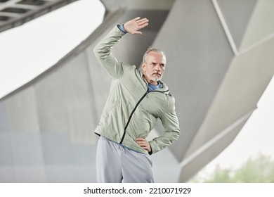 Minimal Waist Up Portrait Of Active Mature Man Warming Up During Outdoor Workout In Urban City Setting, Copy Space