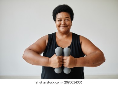 Minimal Waist Up Portrait Of Smiling Senior Woman Working Out Indoors Holding Dumbbells