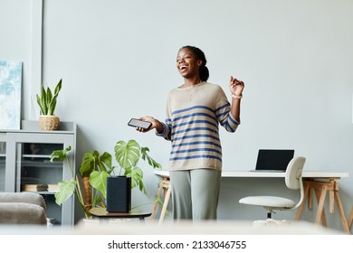 Minimal Waist Up Portrait Of Young African American Woman Dancing To Music At Home Using Smart Speaker