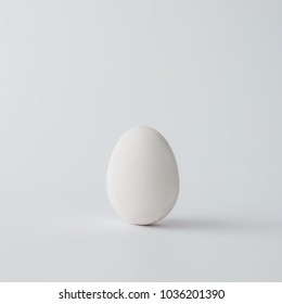 Minimal White Easter Egg On Bright Background. Flat Lay.