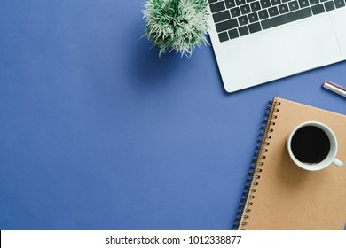 Minimal work space - Creative flat lay photo of workspace desk. Top view office desk with laptop, notebooks and coffee cup on blue color background. Top view with copy space, flat lay photography.
