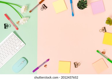 Minimal work space - Creative flat lay photo of workspace desk. Top view office desk with keyboard, mouse and adhesive note on pastel green pink color background. Top view with copy space photography.