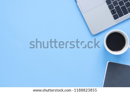 Minimal work space - Creative flat lay photo of workspace desk. Top view office desk with laptop, notebooks and coffee cup on blue color background. Top view with copy space, flat lay photography.