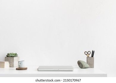 Minimal Workspace, Desk With Laptop Closed Office Supplies, Coffee Paper Cup And Empty Wall Background.