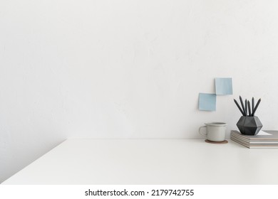 Minimal Workspace. Desk With Office Supplies, Coffee Mug, White Wall And White Empty Product Space.
