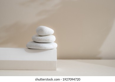 Minimale Zen natürliche Schönheit. Hintergrund für Markenbildung und Produktpräsentation. Stillleben Mockup Foto von weißen Marmorsteinen mit langem Schatten auf beigem Tisch.