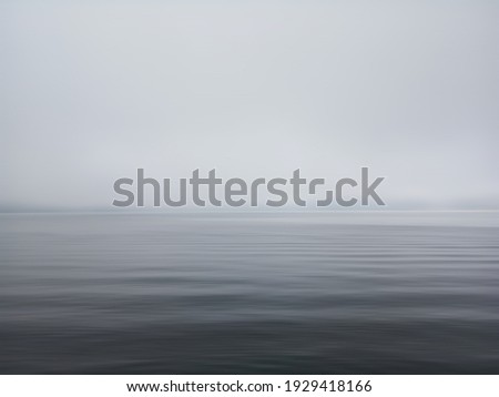Minimalism scene of misty morning background in the sea. Fog over lake wave water. Calm beach view. Tranquil empty landscape with soft blue gray gloomy sky. Nature abstract art backgrounds. Copy space