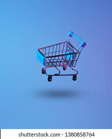 Minimalism Shopping Concept. Toy Shopping Trolley, Neon Night. Photo With Shadow