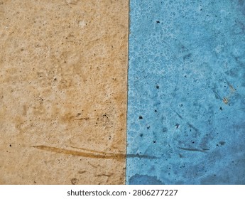 Minimalist abstract background featuring a split contrast texture of weathered orange-beige and rustic blue surfaces with scratches and stains.