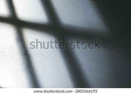 Minimalist abstract composition of light and shadow on brushed steel surface