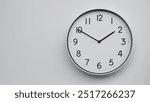 Minimalist Analog Wall Clock with White Face and Simple Black Hands Showing 13.50, 01.50. Ideal for Time Management and Modern Decor Concepts