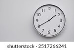 Minimalist Analog Wall Clock with White Face and Simple Black Hands Showing 13.40, 01.40. Ideal for Time Management and Modern Decor Concepts