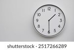 Minimalist Analog Wall Clock with White Face and Simple Black Hands Showing 13.30, 01.30. Ideal for Time Management and Modern Decor Concepts