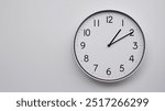 Minimalist Analog Wall Clock with White Face and Simple Black Hands Showing 13.10, 01.10. Ideal for Time Management and Modern Decor Concepts