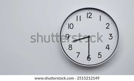 Minimalist Analog Wall Clock with White Face and Simple Black Hands Showing 08.30, 20.30. Ideal for Time Management and Modern Decor Concepts