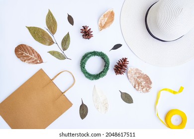 Minimalist Autumn Concept. Paper Bag, White Hat, Ribbon Rope, Dried Leaves, Pine Flowers, Krans Wreath Isolated On White Paper Background. Minimalist Christmas Concept
 - Powered by Shutterstock