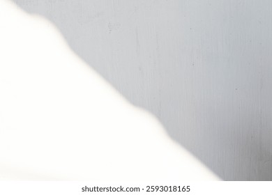 A minimalist backdrop featuring soft, linear shadows on a textured cement wall, adding an artistic and contemporary touch.