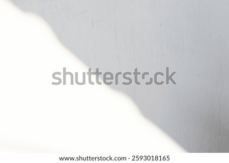 A minimalist backdrop featuring soft, linear shadows on a textured cement wall, adding an artistic and contemporary touch.