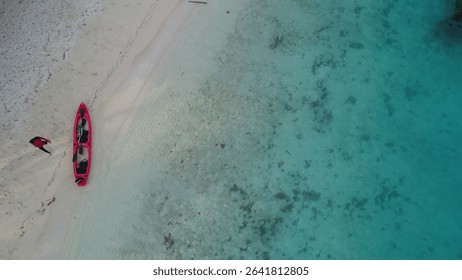Minimalist beach photo of a solitary figure next to a red canoe on pure white sand. - Powered by Shutterstock - Get 15% off with code: PIKWIZARD15