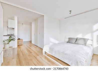 Minimalist bedroom interior design with soft bed with gray pillows against the wall and white built-in wardrobe with natural sunlight - Powered by Shutterstock