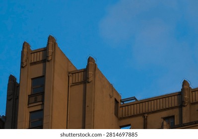 Minimalist brutalist architecture featuring sharp geometric concrete lines against a cobalt blue sky. Matte texture and soft grain highlight institutional legacy and bureaucratic rigidity.