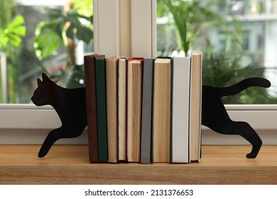 Minimalist Cat Bookends With Books On Window Sill Indoors