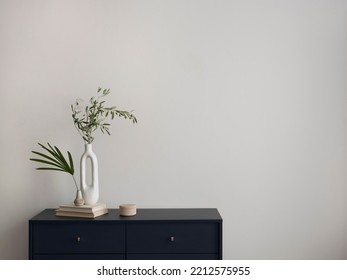 Minimalist composition of elegant and outstanding space with copy space, blue commode, books, green leaves in vase and personal accessories. Home decor. Template.  - Shutterstock ID 2212575955