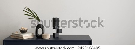 Minimalist composition of elegant and outstanding space with copy space, blue commode, green leaves in vase and personal accessories. Home decor. Template. 