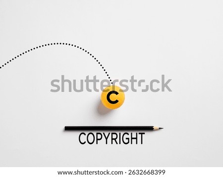 Minimalist composition representing copyright concept with pencil and ball falling on white background