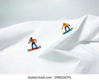 Minimalist concept photo of two miniature snowboards racing.