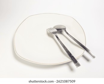 Minimalist Dining Setting with Elegant Plate and Silverware on White Background