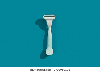 Minimalist elegance: Razor in sharp relief against a bold blue backdrop with dramatic shadows