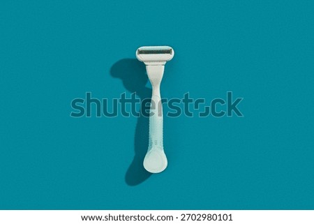 Minimalist elegance: Razor in sharp relief against a bold blue backdrop with dramatic shadows