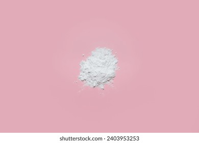 A minimalist and elegant composition featuring a pristine white face powder delicately arranged on a soft pastel pink background