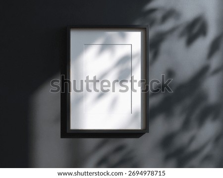 Minimalist empty picture frame casting shadows on a dark wall.