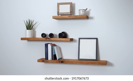 minimalist floating shelf made of wood with books and a picture on it - Shutterstock ID 1917067673
