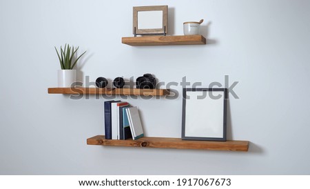 minimalist floating shelf made of wood with books and a picture on it