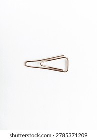 Minimalist gold triangular wire paper clip placed horizontally on a clean white background