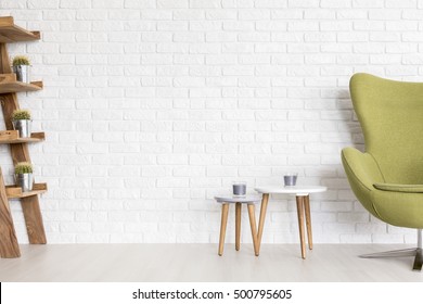 Minimalist Interior With White Brick Wall And Olive Green Upholstered Egg Chair