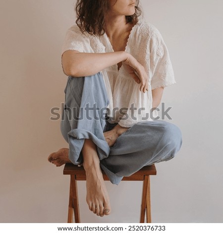 Similar – barefoot young woman sitting barefoot in a window frame