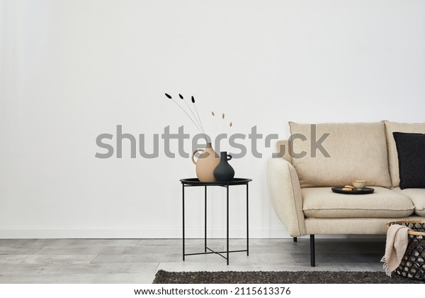 Minimalist living room interior design with beige sofa,\
creative metal side table and modern home accessories. Wallpaper.\
Copy space. Template. \
