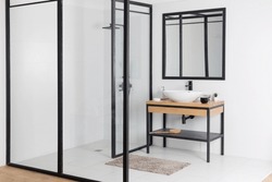 Minimalist Modern Bathroom With Shower Cabin, Mirror In Black Frame, Sink On Wooden Table And White Walls, Copy Space