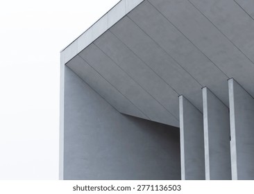 Minimalist modern building facade with angular gray panels and vertical fins. Clean geometric architecture creates a contemporary exterior detail. Ideal for urban design, construction, and background