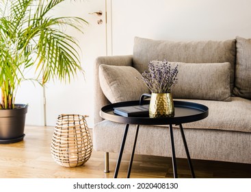 Minimalist modern home living room black accent piece table with gold color vase and book black metal table on natural oak hardwood floor.