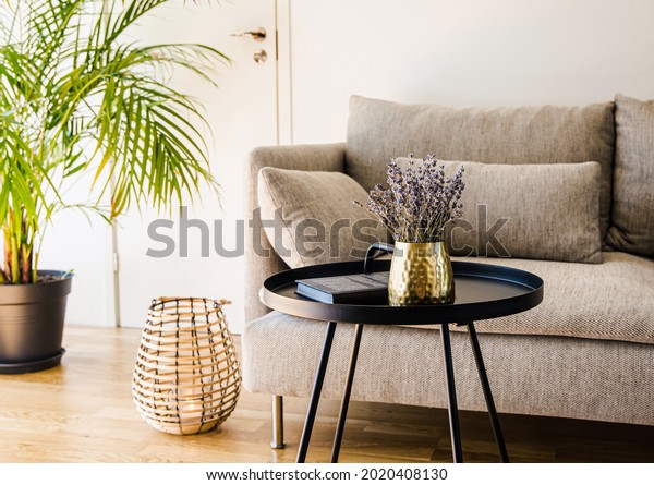 Minimalist modern home living room black accent\
piece table with gold color vase and book black metal table on\
natural oak hardwood\
floor.