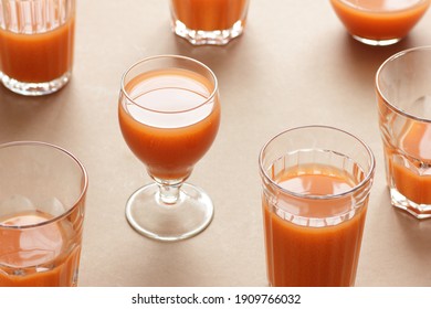 Minimalist monochrome geometric abstract arrangement of  vintage glasses with orange carrot juice on beige and brown background, isometric design pattern, copy space abstract modern art design concept