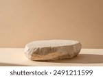 Minimalist natural stone podium for elegant product display on plain beige background, ideal for highlighting exclusive items in simple yet sophisticated commercial presentations