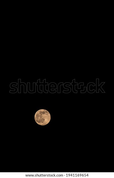 Minimalist nature background with lonely moon in the
night sky. Minimal dark landscape with bright orange moon in pitch
darkness. 