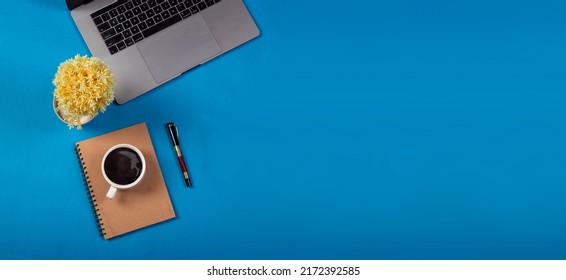 Minimalist Office Table With Blue Background And Office Supplies.