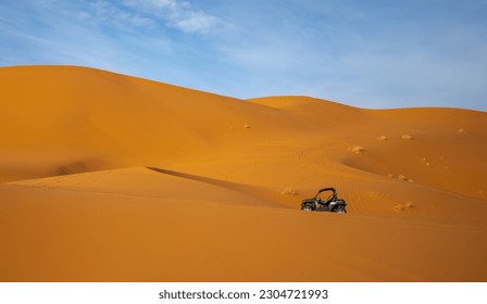 A minimalist photo of a dune buggy in the dunes of the Sahara Desert near Mergouza, Morocco.